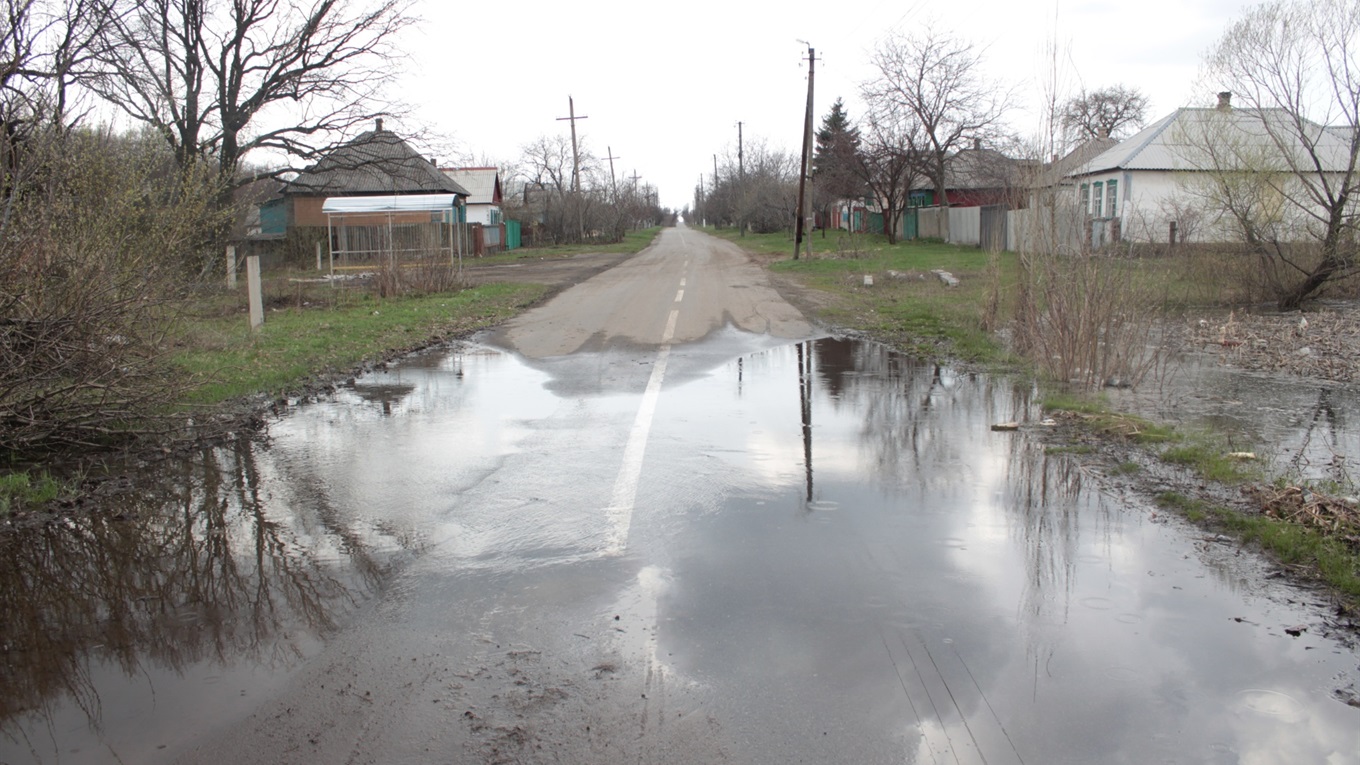 В Попасной водоем вышел из берегов и подтапливает автомобильную дорогу