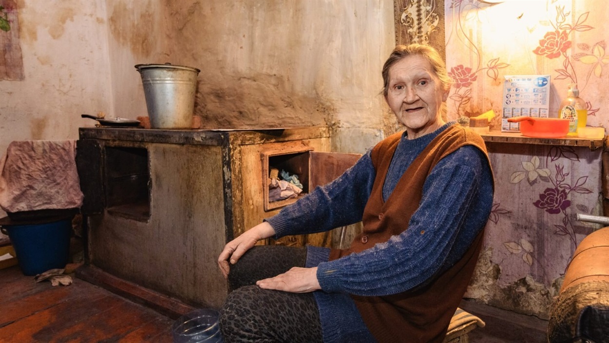 Жінка сидить біля печі