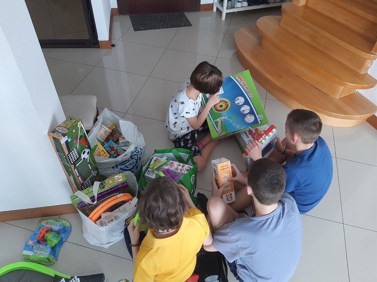 Діти роздивляються іграшки, які їм надали від фонду
