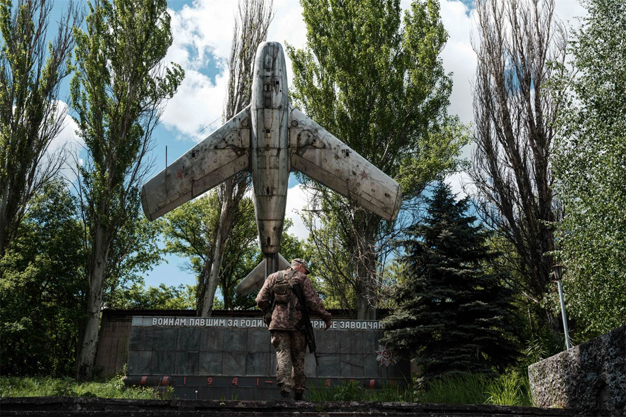  «Украинский солдат смотрит на неразорвавшийся снаряд в поселке Нью-Йорк Донецкой области». Дуже промовиста світлина.