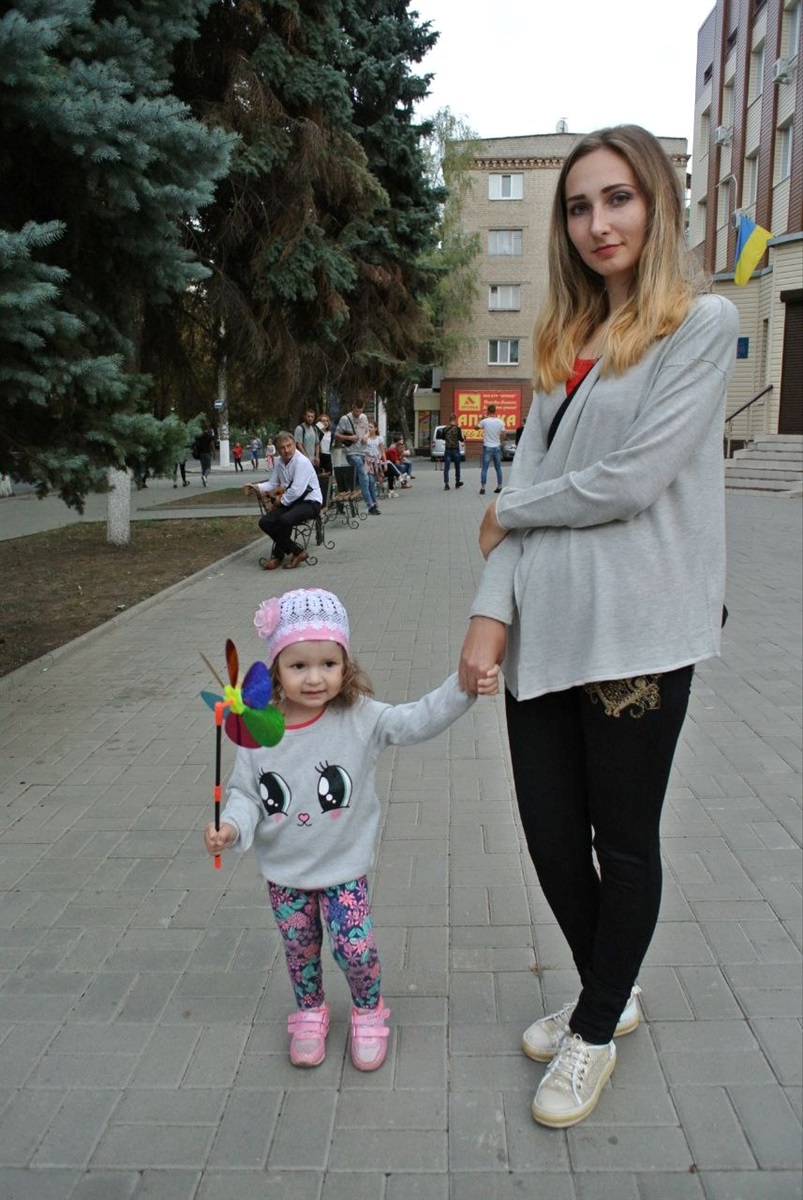 Наталія з донькою біля Центральної поліклініки і їхнього будинку
