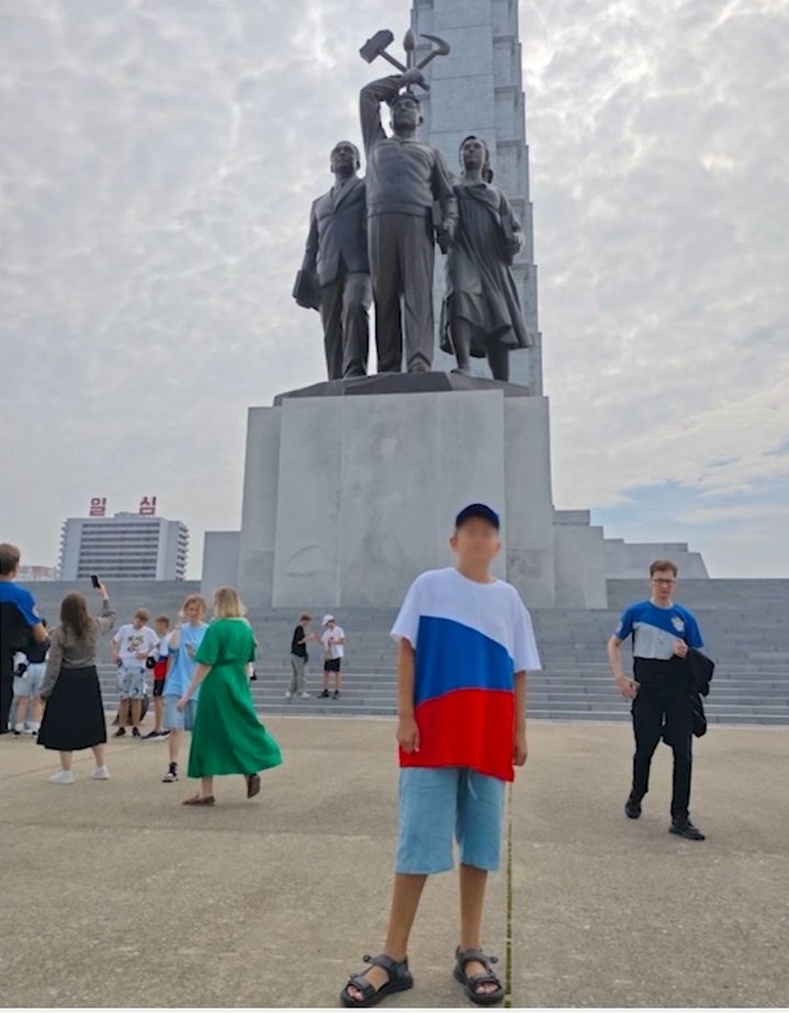 Михайло на фоні монумента ідей чучхе у Пхеньяні, збудованого у 1982 році на честь 70-річчя вождя КНДР Кім Ір Сена