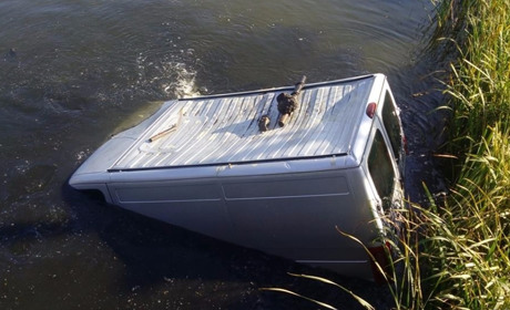 Подробиці нічної аварії: щоб врятувати пасажира авто, поліцейський стрибнув у воду в бронежилеті