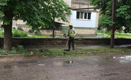 Косять траву та прибирають: у Красногорівці під обстрілами наводять лад у місті