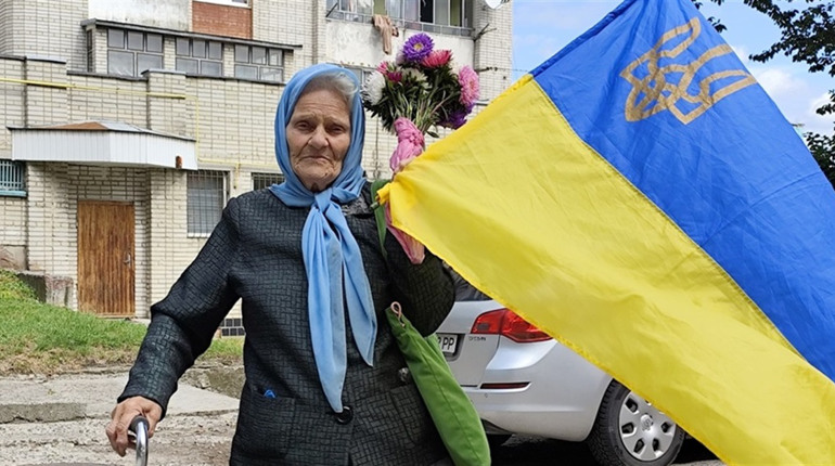 Старша жінка з Херсонщини розчулила мережу на День прапора синьо-жовтим стягом і шкарпетками