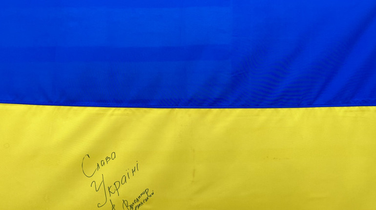 Волонтери розігрують прапор України з підписом Президента