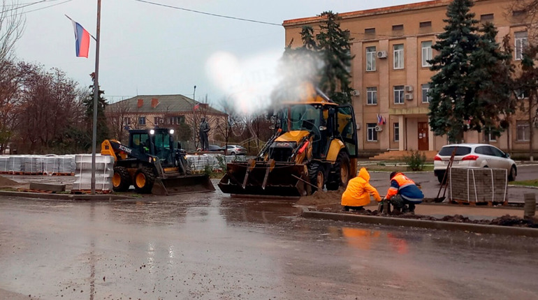 Робітники кладуть тротуарну плитку просто в калюжі на головній площі Генічеська