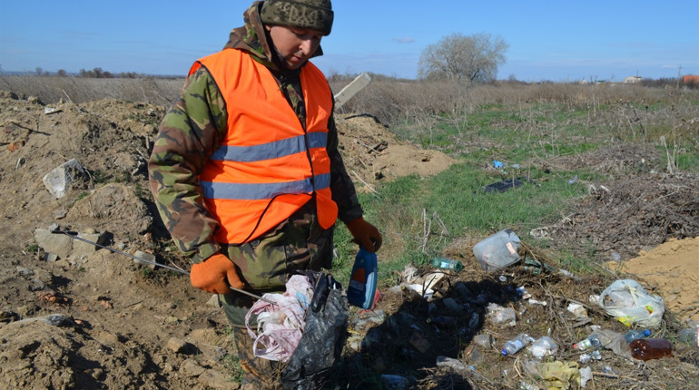 Комунальники збирають і перебирають сміття на стихійному звалищі руками. Що вони в ньому шукають